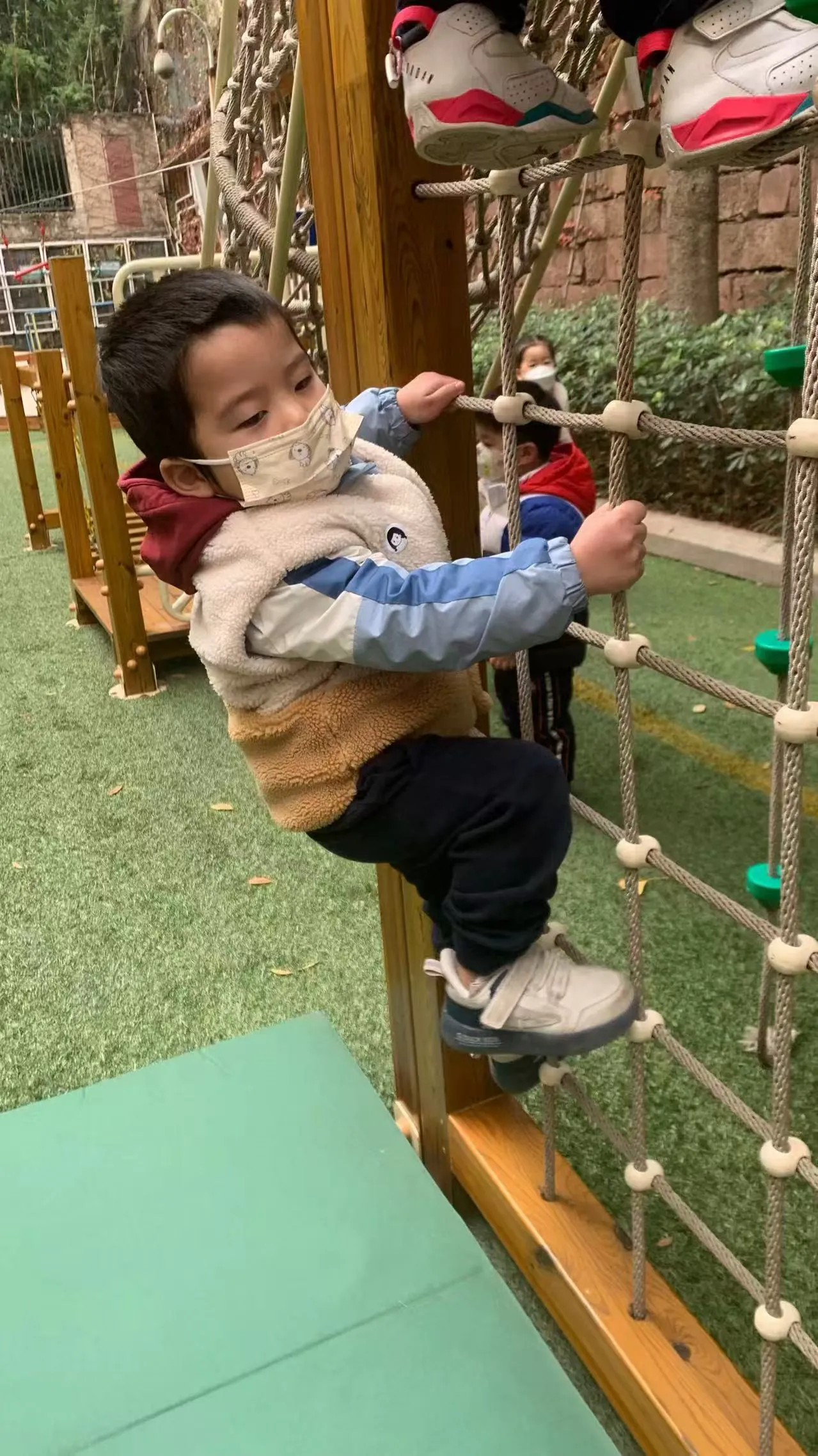派派在老师守护下攀爬绳网