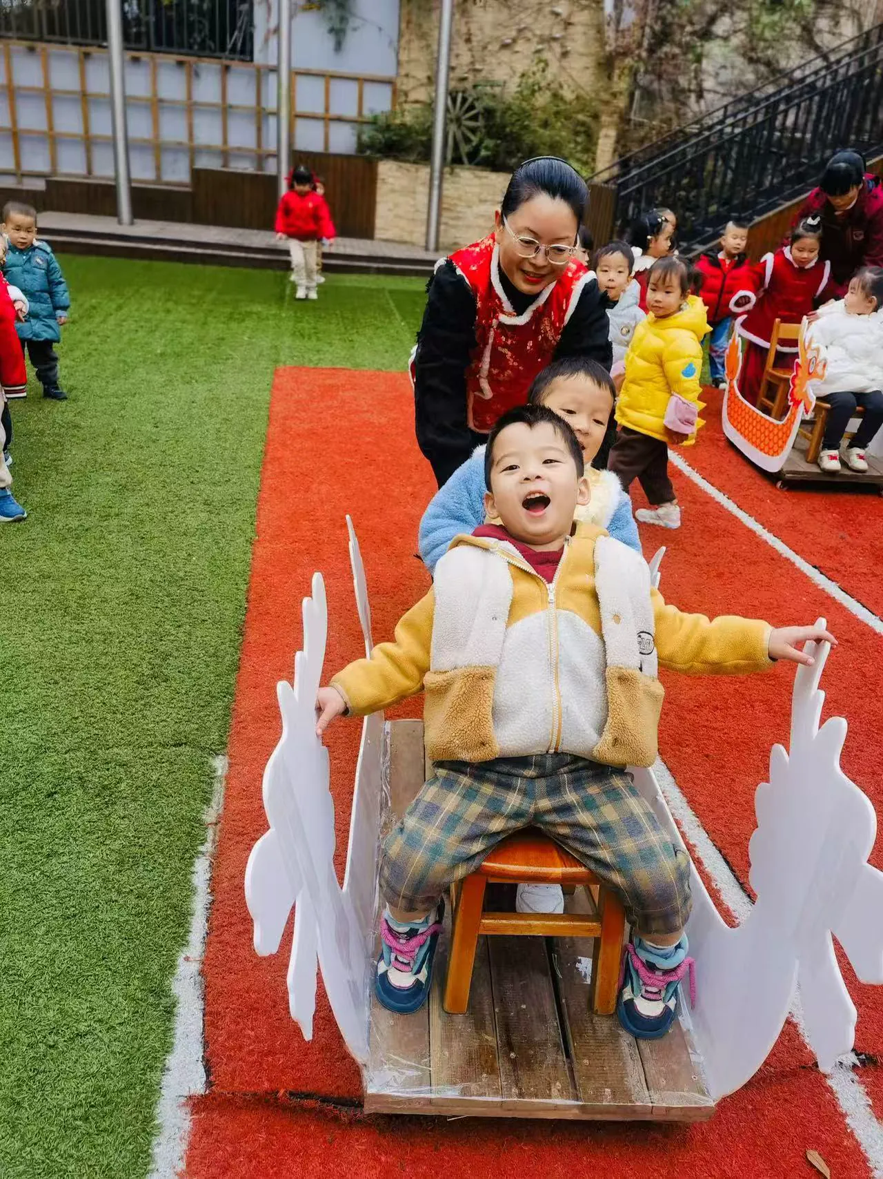 派派在老师帮助下参加户外火箭游戏