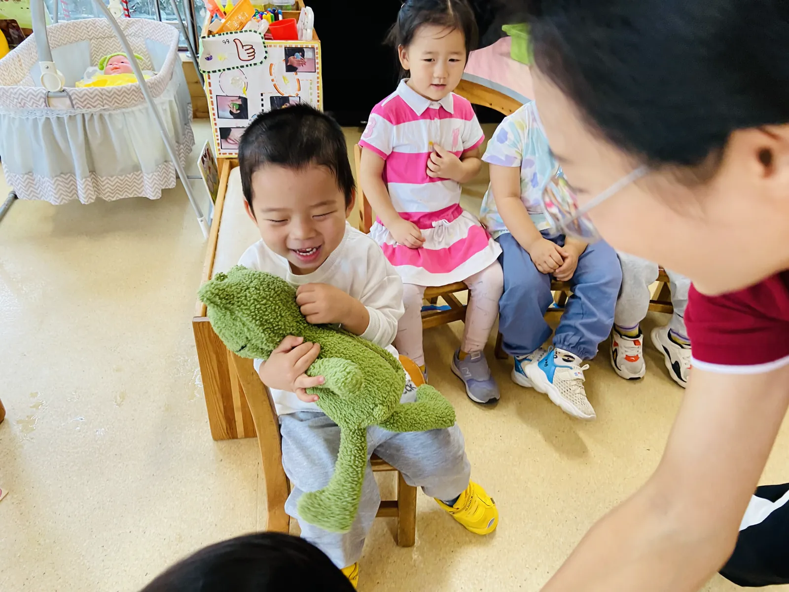 派派抱着富贵儿在老师面前开心大笑
